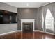 Living room with hardwood floors, fireplace, large TV and natural light from windows at 4431 Hickory Stick Row, Greenwood, IN 46143