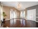 Bright living room features rich hardwood floors, French doors, transom windows, and a decorative chandelier at 4431 Hickory Stick Row, Greenwood, IN 46143