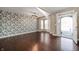 Open-concept living room featuring hardwood floors, large bay window, and decorative wallpaper at 4431 Hickory Stick Row, Greenwood, IN 46143