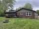 Brick home with a deck, fenced in backyard and a fire pit at 530 Lansdowne Rd, Indianapolis, IN 46234