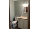 This bathroom features a toilet, vanity with a sink, and a mirror with lights at 530 Lansdowne Rd, Indianapolis, IN 46234