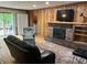 Cozy living room featuring fireplace, built-in shelving, and wood paneling at 530 Lansdowne Rd, Indianapolis, IN 46234