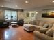 Open-concept living room with hardwood floors, a sectional sofa, and views into the dining area at 530 Lansdowne Rd, Indianapolis, IN 46234
