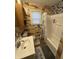 Cozy bathroom features a tub with shower, patterned walls, and a well-lit vanity area at 5317 E 20Th Pl, Indianapolis, IN 46218