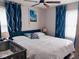 Cozy bedroom with a comfortable queen-sized bed, stylish curtains, and a ceiling fan at 5317 E 20Th Pl, Indianapolis, IN 46218