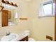 Modest bathroom features a sink and vanity and a toilet, as well as window for natural light at 5549 Hollister Dr, Indianapolis, IN 46224