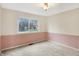 Bedroom with window, neutral walls, neutral carpet, and updated baseboards at 5549 Hollister Dr, Indianapolis, IN 46224