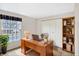 Home office features a large window for natural light, built-in bookcase, and neutral tones at 5549 Hollister Dr, Indianapolis, IN 46224