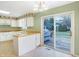 Bright kitchen featuring white cabinets, eat-in breakfast bar, and glass doors to the back yard at 5549 Hollister Dr, Indianapolis, IN 46224
