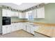 Bright kitchen featuring white cabinets, updated appliances, and tile floors at 5549 Hollister Dr, Indianapolis, IN 46224