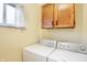 Bright laundry area with overhead cabinet space and window providing ample natural light at 5549 Hollister Dr, Indianapolis, IN 46224