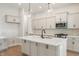 Spacious kitchen boasts white cabinets, stainless steel appliances, pendant lights, and a center island at 555 Gilder Dr, Carmel, IN 46032