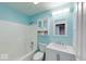 This bathroom features blue walls and a white shower and vanity for a clean and bright look at 6608 Rushing, Noblesville, IN 46062