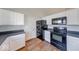 Kitchen featuring black appliances, white cabinets, and wood-look flooring at 6608 Rushing, Noblesville, IN 46062