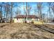 Back of beige brick ranch style house featuring a new wood deck on a wooded lot at 6775 W Woodcrest Dr, Greenfield, IN 46140