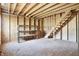 Unfinished basement with exposed wood framing, shelving, and a staircase at 6775 W Woodcrest Dr, Greenfield, IN 46140