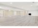 Finished basement with vinyl flooring, bright lighting, and a fireplace at 6775 W Woodcrest Dr, Greenfield, IN 46140