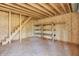 Unfinished bonus room featuring raw wood, a staircase to the upper level, and wood shelving for customizable storage options at 6775 W Woodcrest Dr, Greenfield, IN 46140