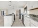 Modern kitchen with white cabinetry, granite countertops, and stainless steel appliances, flowing into a bright and airy living space at 6775 W Woodcrest Dr, Greenfield, IN 46140