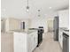A well-appointed kitchen with a central island, sleek appliances, and ample counter space flows seamlessly into the living area at 6775 W Woodcrest Dr, Greenfield, IN 46140