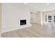 Bright living room featuring a decorative fireplace, hardwood floors, and double doors to the exterior, perfect for modern living at 6775 W Woodcrest Dr, Greenfield, IN 46140