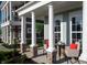 Inviting front porch area with stylish seating, stone pillars, and views of the surrounding landscape at 746 Astor Dr, Carmel, IN 46032