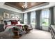 Spacious bedroom boasts a decorative wood tray ceiling, with ample natural light and cozy seating at 746 Astor Dr, Carmel, IN 46032