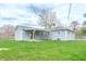 Backyard view featuring a covered patio and ample green space for outdoor activities at 7610 Brehob Rd, Indianapolis, IN 46217