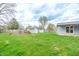 Spacious backyard with lush grass, mature trees, and storage sheds for convenience at 7610 Brehob Rd, Indianapolis, IN 46217