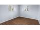 Comfortable bedroom featuring neutral paint, hardwood floors, and two windows for ample sunlight at 7610 Brehob Rd, Indianapolis, IN 46217