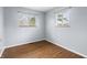 Bedroom featuring two windows, hardwood floors, neutral paint, and natural light at 7610 Brehob Rd, Indianapolis, IN 46217