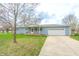 Inviting home exterior with a well-maintained lawn, a driveway, and an attached garage at 7610 Brehob Rd, Indianapolis, IN 46217