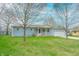 Well-kept home with a green lawn, a driveway, and mature trees for added curb appeal at 7610 Brehob Rd, Indianapolis, IN 46217