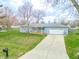 Charming home with a well-manicured lawn and a long driveway leading to the garage at 7610 Brehob Rd, Indianapolis, IN 46217