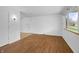 Bright living room with wood floors, a large window, and fresh, white walls at 7610 Brehob Rd, Indianapolis, IN 46217