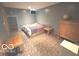 A glimpse of the basement bedroom, with a simple bed and furnishings at 7811 W 700 S, Jamestown, IN 46147