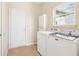Functional laundry room with washer, dryer, storage cabinet, and access to the exterior at 8535 Fenton Tower Dr, Indianapolis, IN 46259
