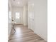 Bright hallway with light wood floors, modern art, and a white front door at 8623 Lester Pl, Pendleton, IN 46064