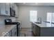 Bright kitchen with stainless steel appliances, gray cabinets, a kitchen island with a sink, and seating at 8623 Lester Pl, Pendleton, IN 46064