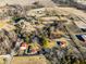 Aerial view showcases the layout of a rural property with red-roofed buildings surrounded by trees at 1001 N 750 W, Bargersville, IN 46106