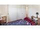 Simple bedroom with hardwood floors, a patterned blanket, and sliding closet doors for functional storage at 1001 N 750 W, Bargersville, IN 46106