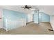 A spacious carpeted bedroom features blue walls, a ceiling fan, and built-in storage at 118 S 11Th Ave, Beech Grove, IN 46107