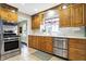 The charming kitchen is equipped with stainless appliances, wood cabinets, and white countertops at 118 S 11Th Ave, Beech Grove, IN 46107