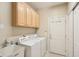 Functional laundry room with washer, dryer, utility sink, and storage cabinets at 12880 Oxbridge Pl, Fishers, IN 46037