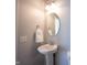Cozy powder room features a pedestal sink, a round mirror, a towel ring, and a two-bulb vanity light at 12964 Walbeck Dr, Fishers, IN 46037