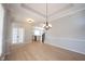 Dining room with hardwood floors leading to the foyer and modern kitchen with black countertops at 12964 Walbeck Dr, Fishers, IN 46037