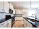 Modern kitchen features white cabinets, stainless appliances, and black countertops at 12964 Walbeck Dr, Fishers, IN 46037