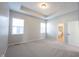 Spacious main bedroom with a tray ceiling, two windows, and neutral carpeting, creating a serene atmosphere at 12964 Walbeck Dr, Fishers, IN 46037