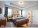 A serene main bedroom featuring a tray ceiling, natural light, and en-suite bathroom at 12964 Walbeck Dr, Fishers, IN 46037