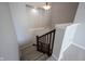 Carpeted stairs with a wooden railing, a light fixture, and a display shelf at 12964 Walbeck Dr, Fishers, IN 46037